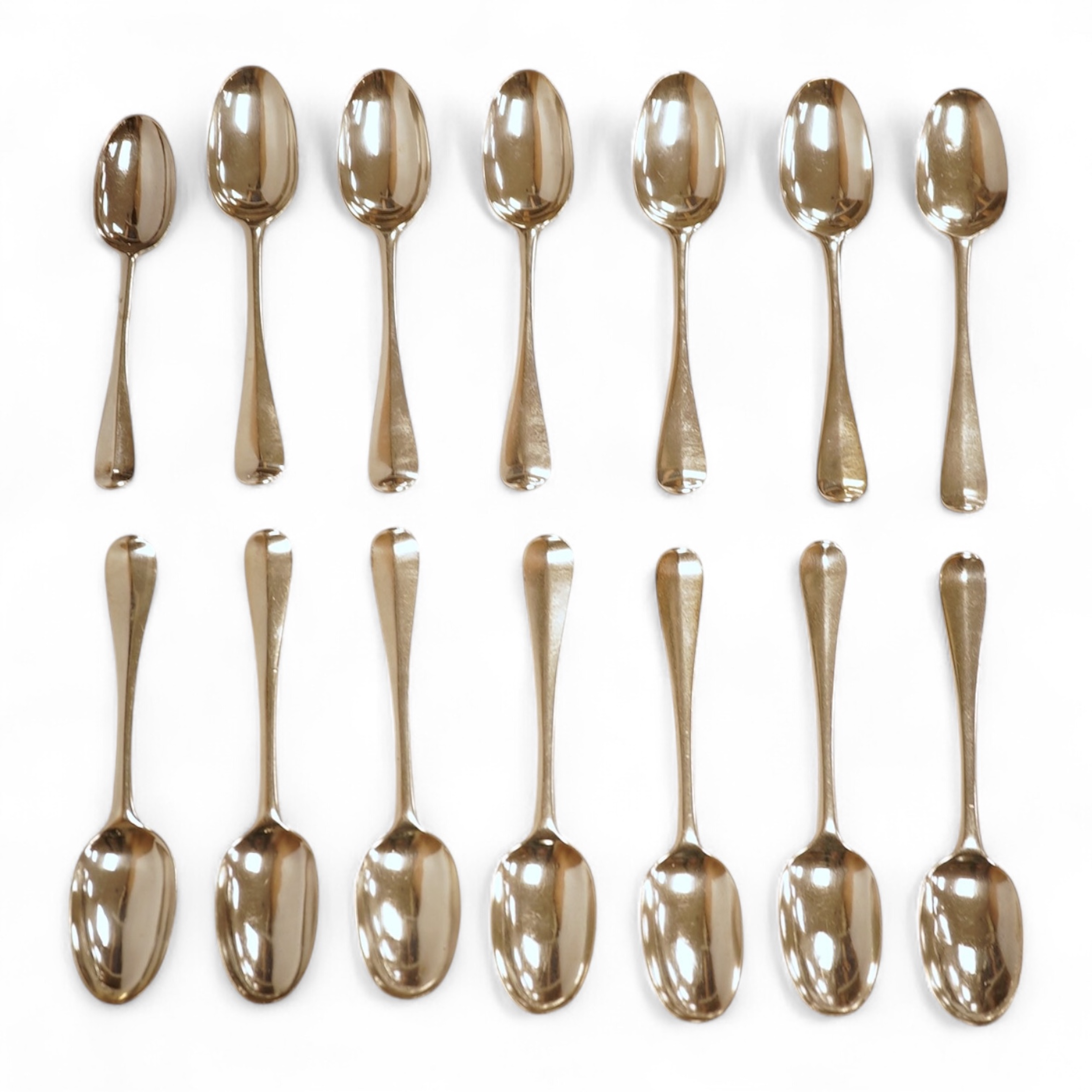 A matched set of seven Queen Anne silver Hanoverian pattern dessert spoons, maker's mark rubbed, five London, 1708, 17.5cm, together with seven other silver base mark Hanoverian pattern dessert spoons, various dates and